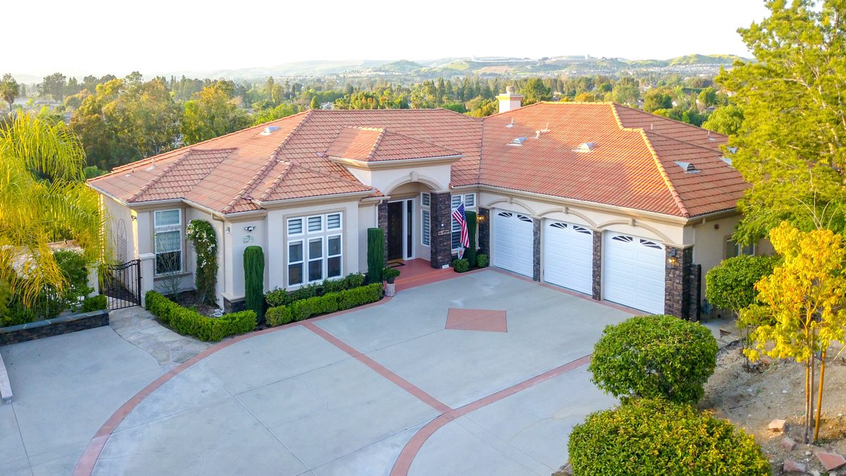 Aerial view of a hillside estate on acreage in Orange County horse country