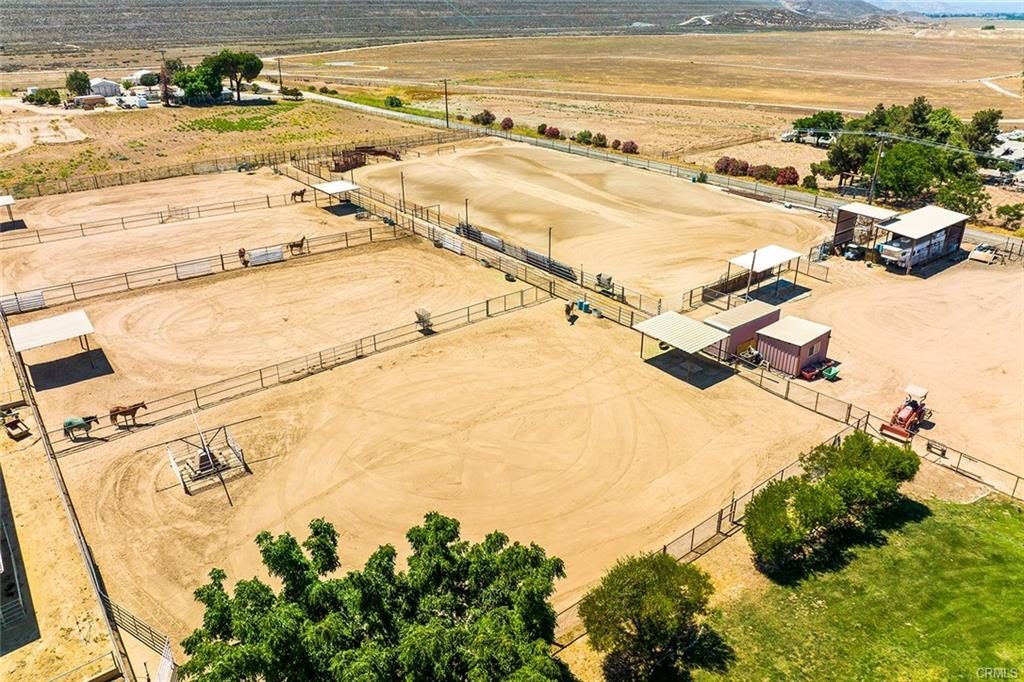 Aerial view of an equestrian property showing arena, fencing and outbuildings