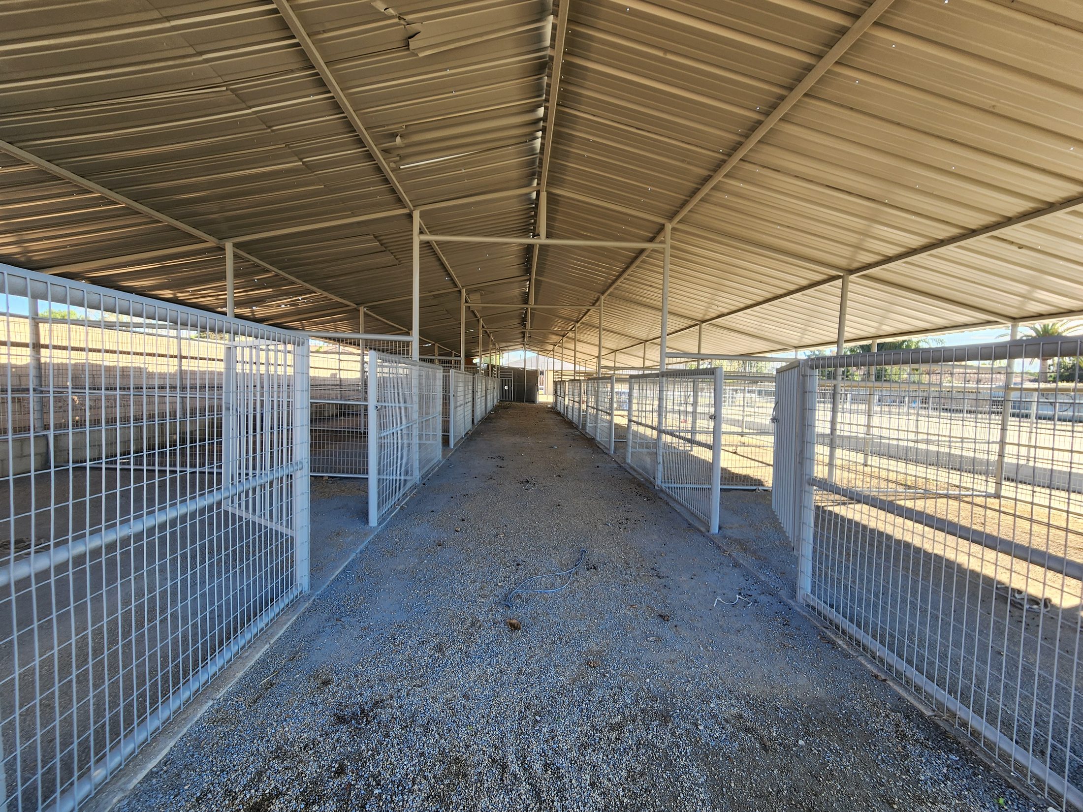 Barn breezeway lined with stalls on a Southern California horse property