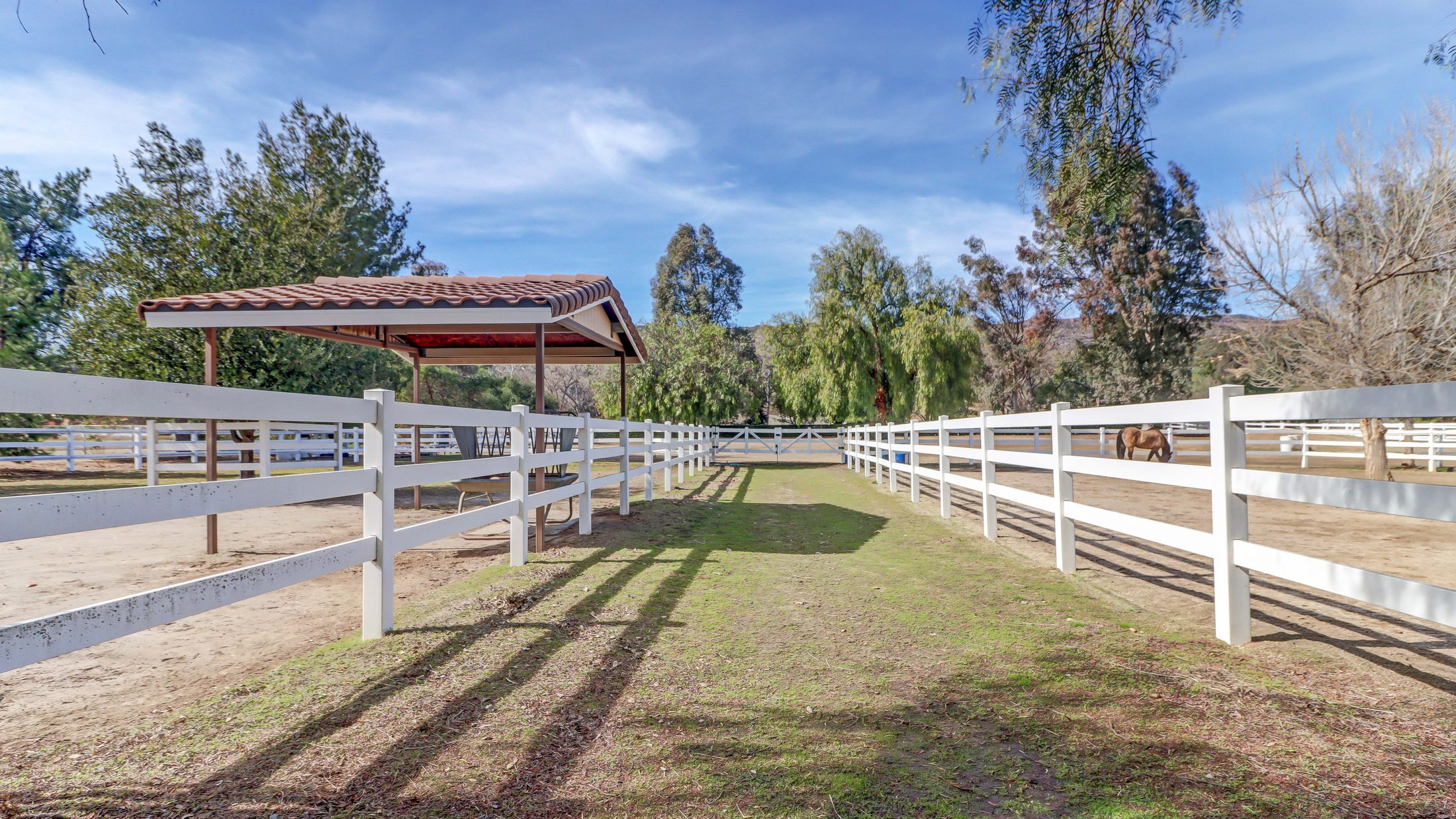 White-fenced paddock and shade structure on a Southern California horse property listed by Sharon Kaak